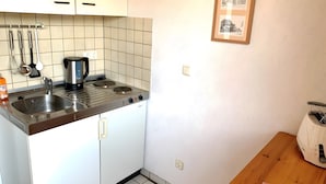 Eine Küche mit Herd, Spüle und verschiedenen Kochutensilien.