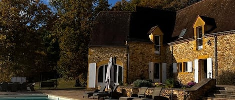 Un edificio de piedra con piscina y jacuzzi.