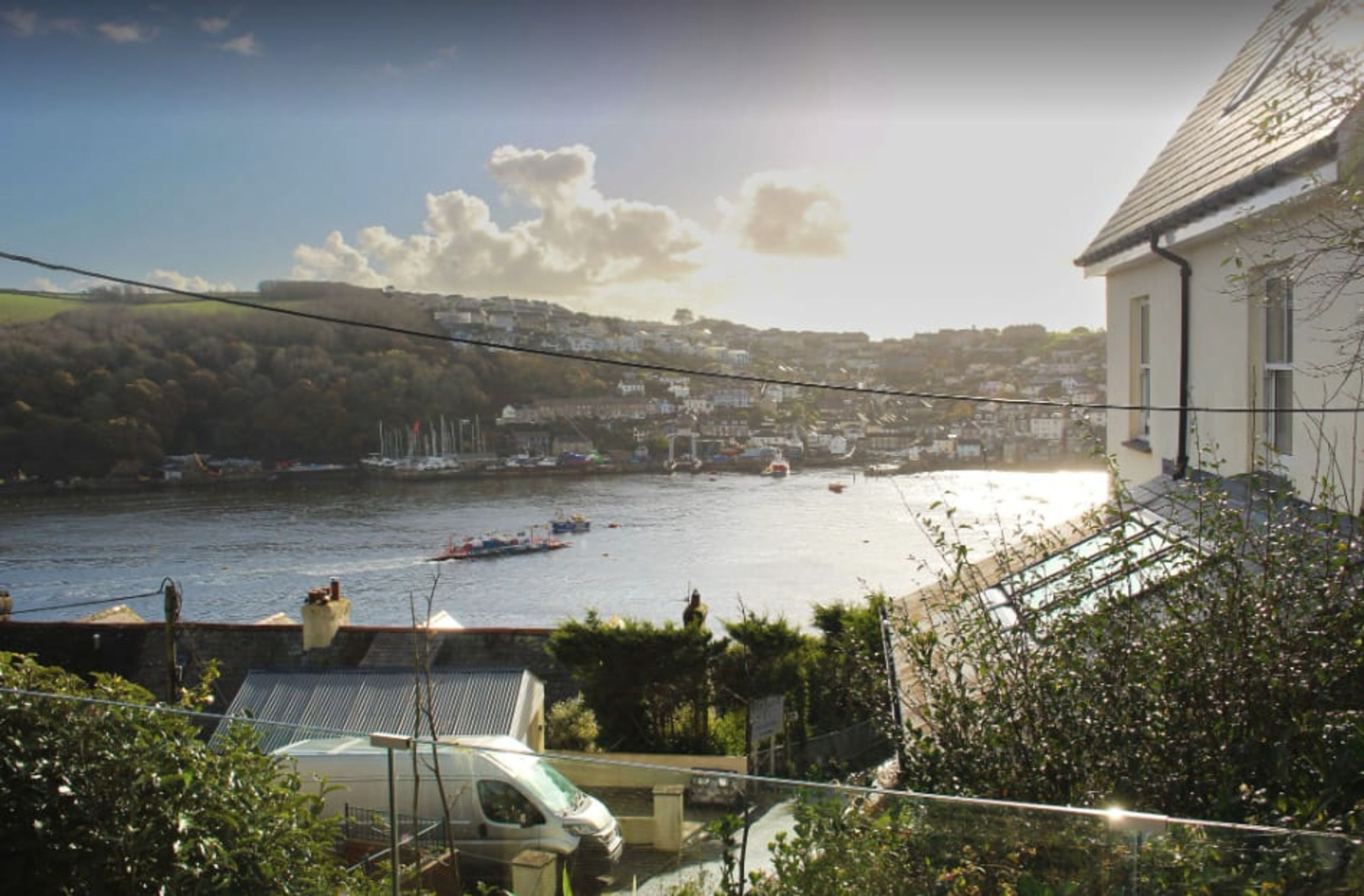 A river with boats, a residential area, and a building with a sloped roof.