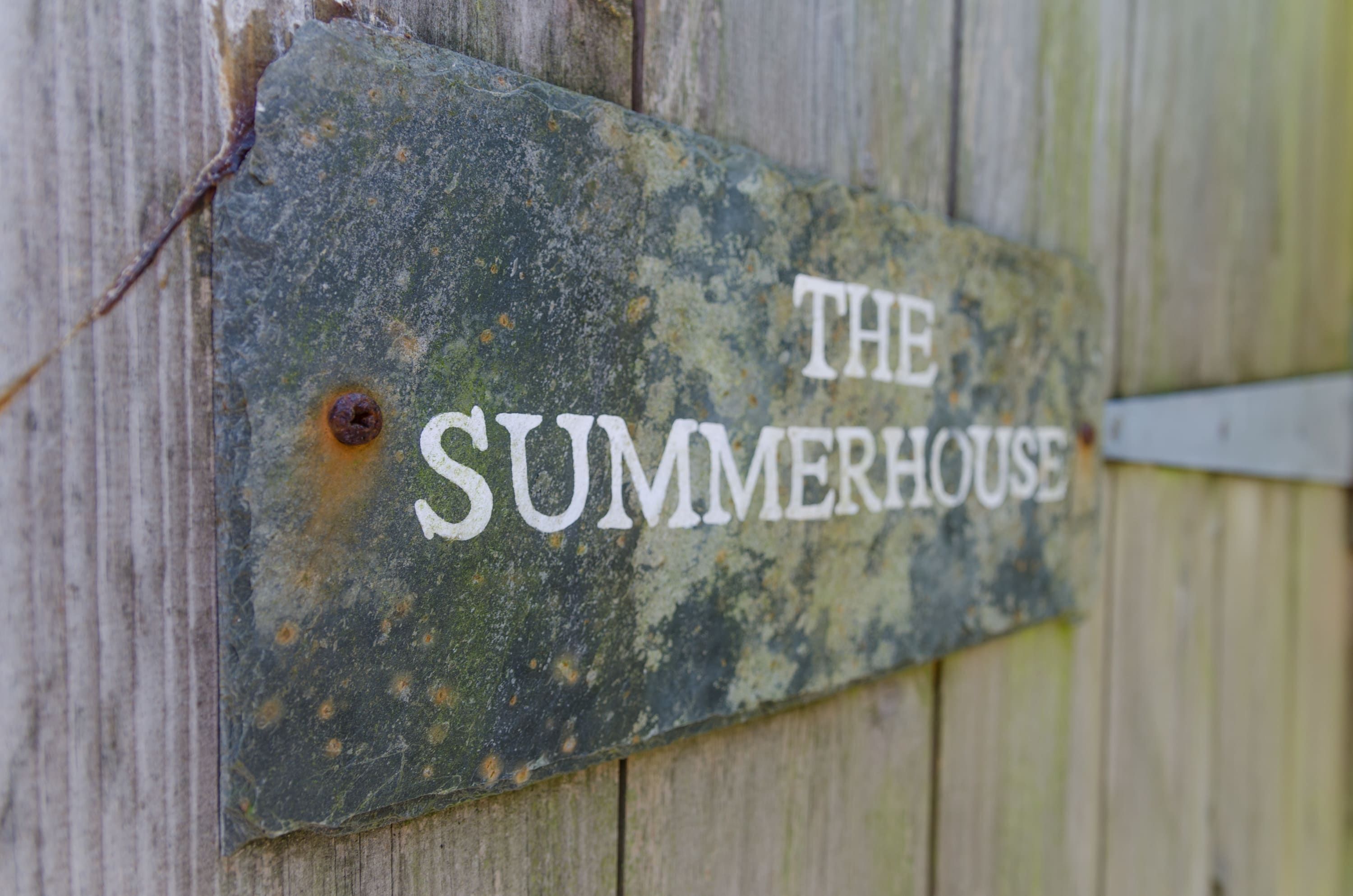 A weathered sign with the words 'THE SUMMERHOUSE' on it.