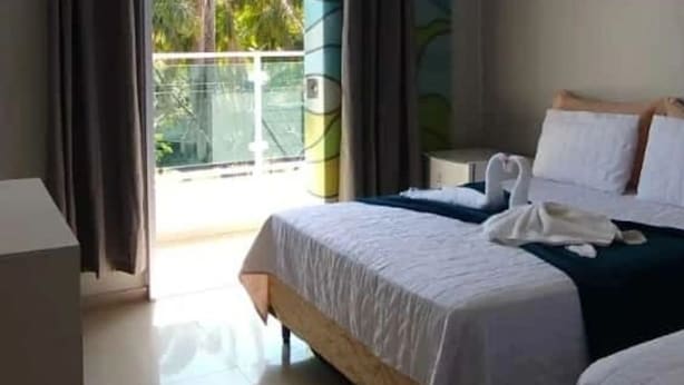 Ein Hotelzimmer mit einem Bett, einem Nachttisch und Blick ins Freie.