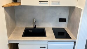A kitchen with a sink, a stove, and a dishwasher. - Apartment for 2 People (25 m²) in Kreuzau (Kreuzau)