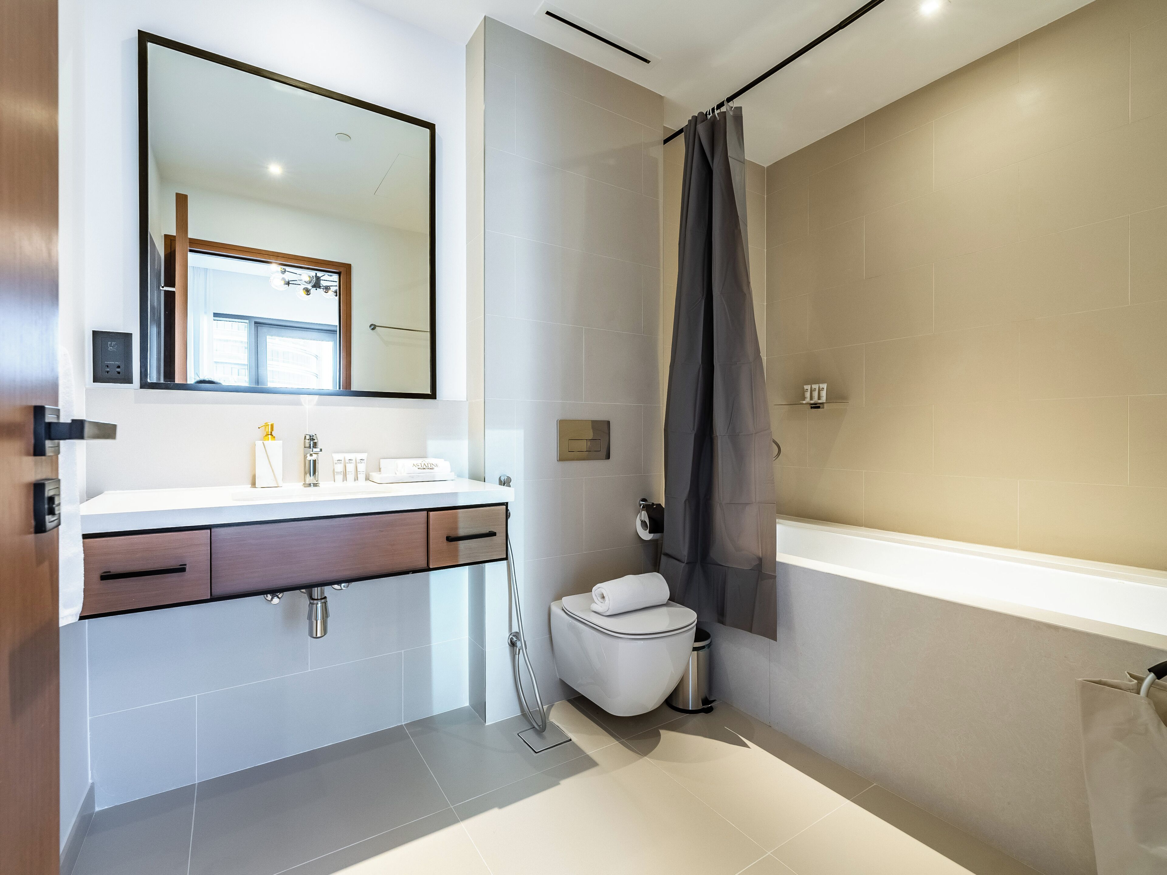 Une salle de bain moderne avec un lavabo blanc, un miroir et une baignoire.