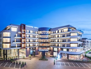 A modern hotel with a curved facade, multiple balconies, and a well-lit entrance. - Mercure Oradea  (Oradea)