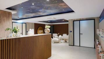 Zona de recepción de un spa, con un mostrador de madera, un cartel que dice 'spa' y un techo decorado con un diseño de cielo estrellado.