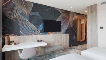 A modern hotel room with a desk, chair, and a bed.