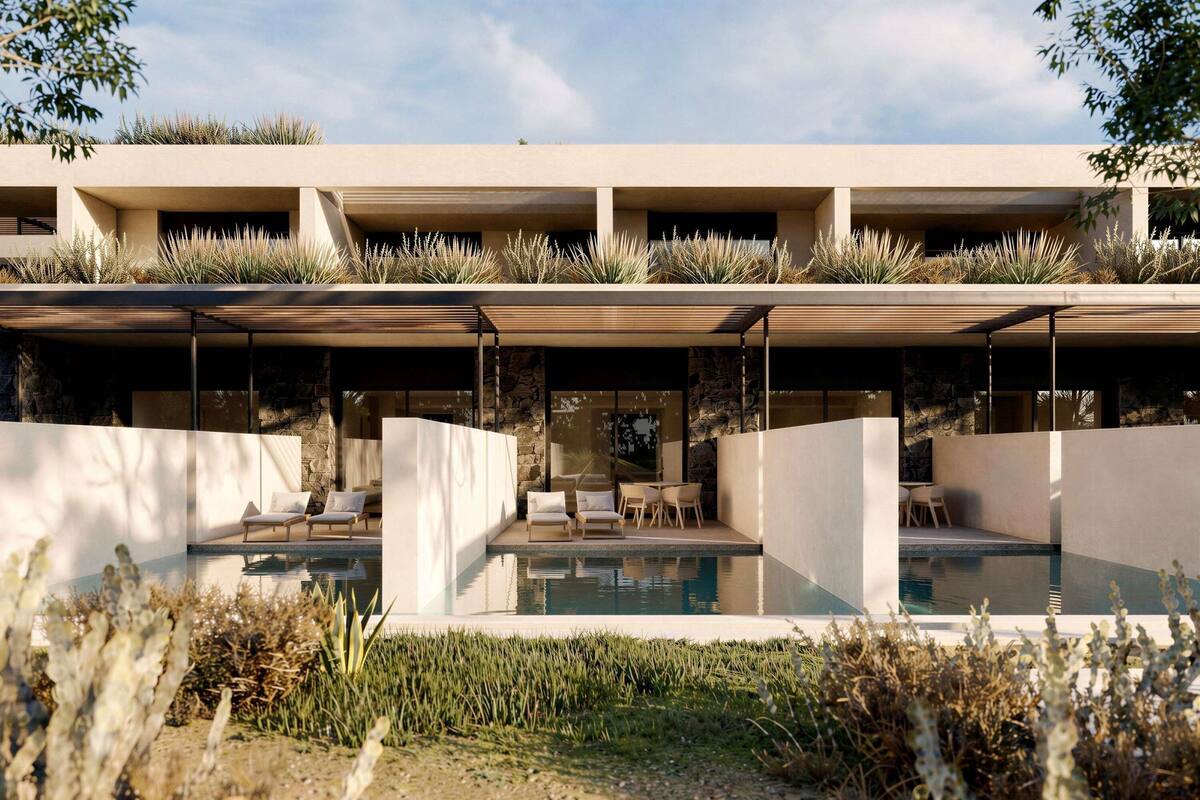 En moderne bygning med pool, udendørs siddepladser og en facade af sten.