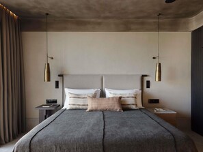 A modern bedroom with a large bed, two bedside tables, and a hanging light fixture. - Nirema Hotel & Spa Samos-Mgallery Collection (Samos)