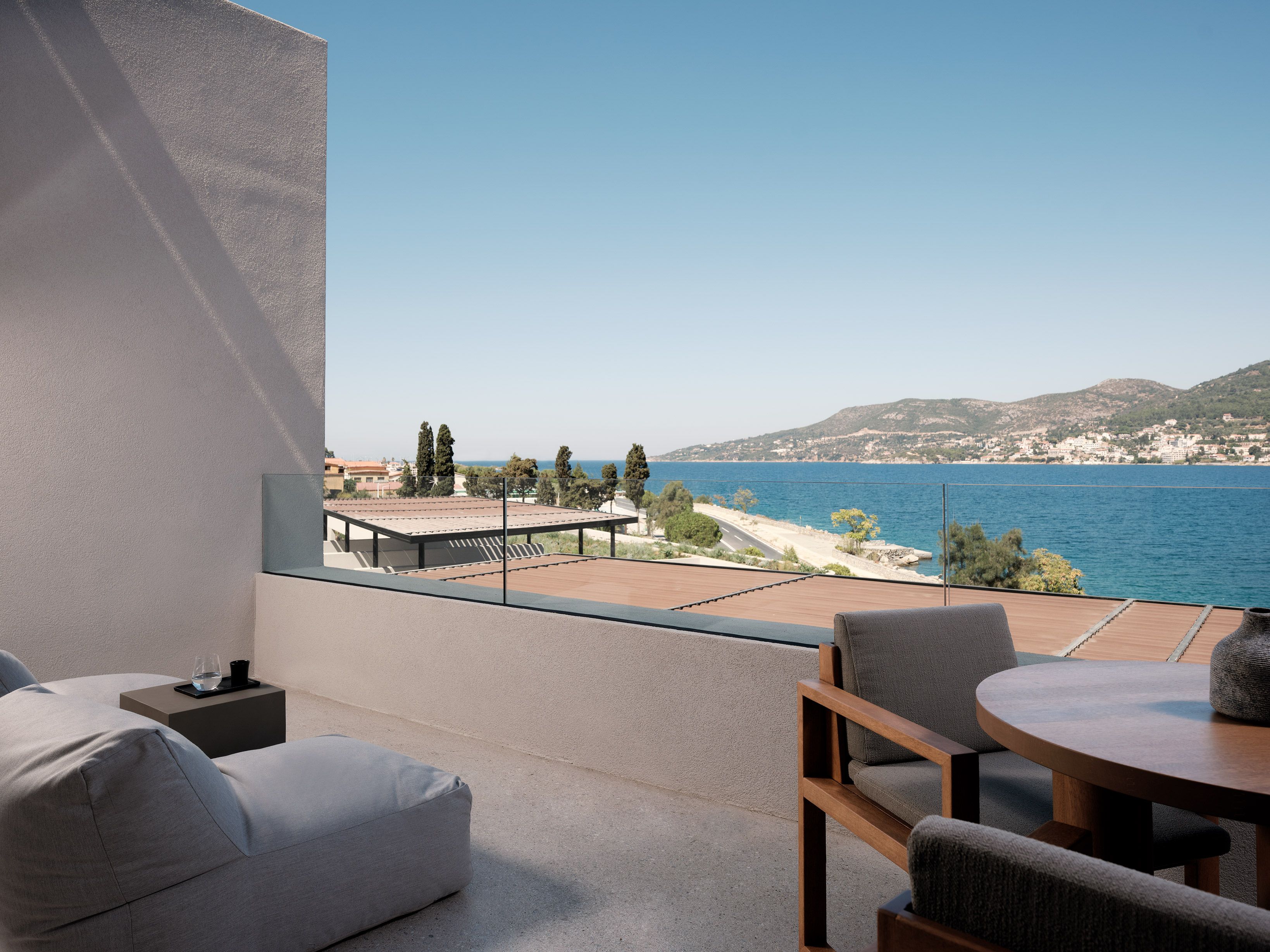 Un balcon avec vue sur la mer, une table et un canapé.