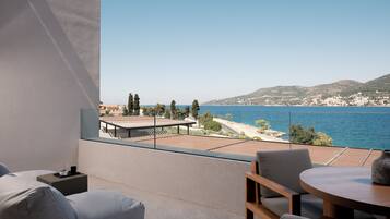 Un balcon avec vue sur la mer, une table et un canapé.