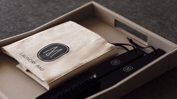 A beige box containing a black portable charger and a beige cloth with a logo.