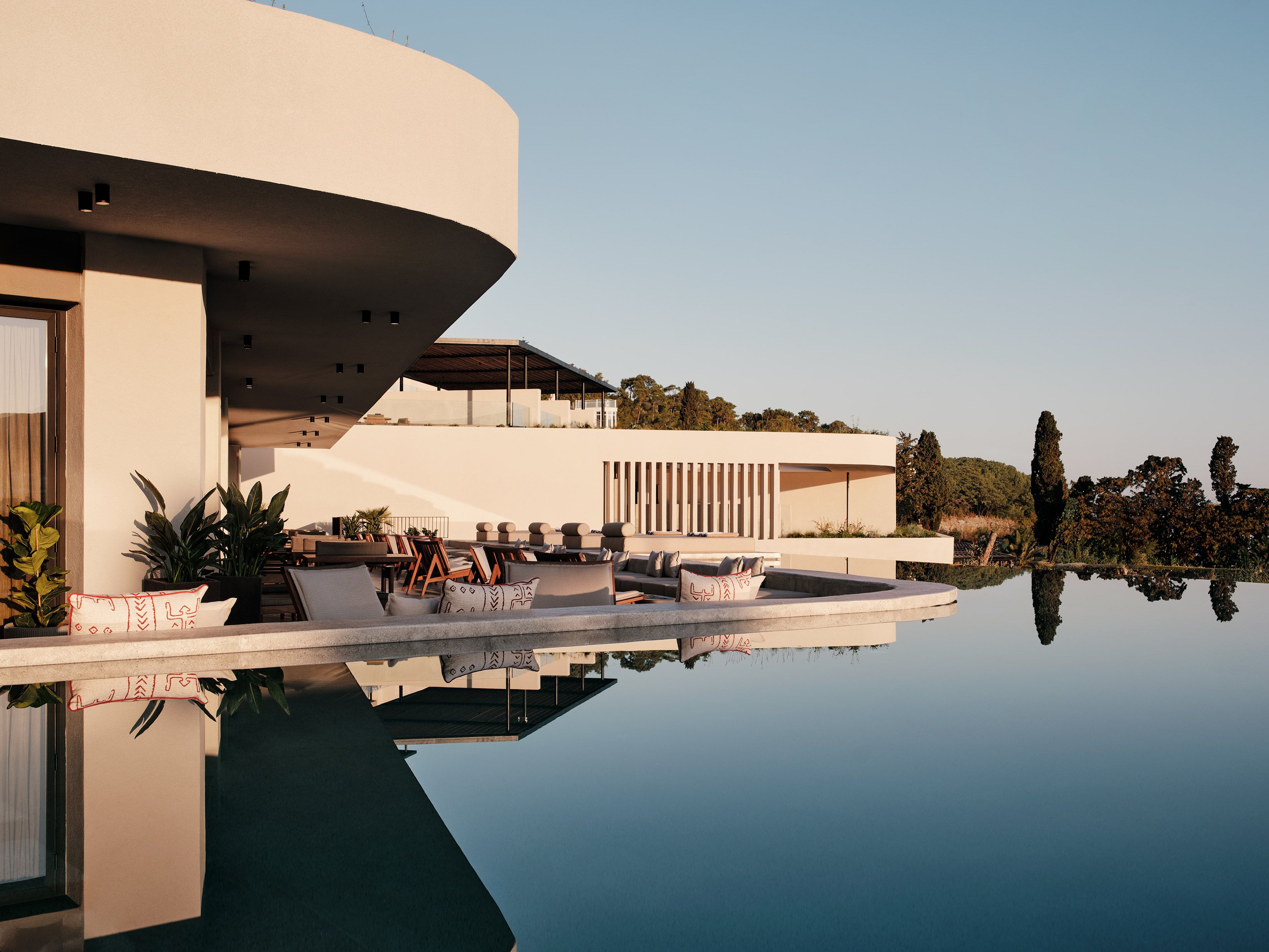A modern building with a pool reflecting its architecture.