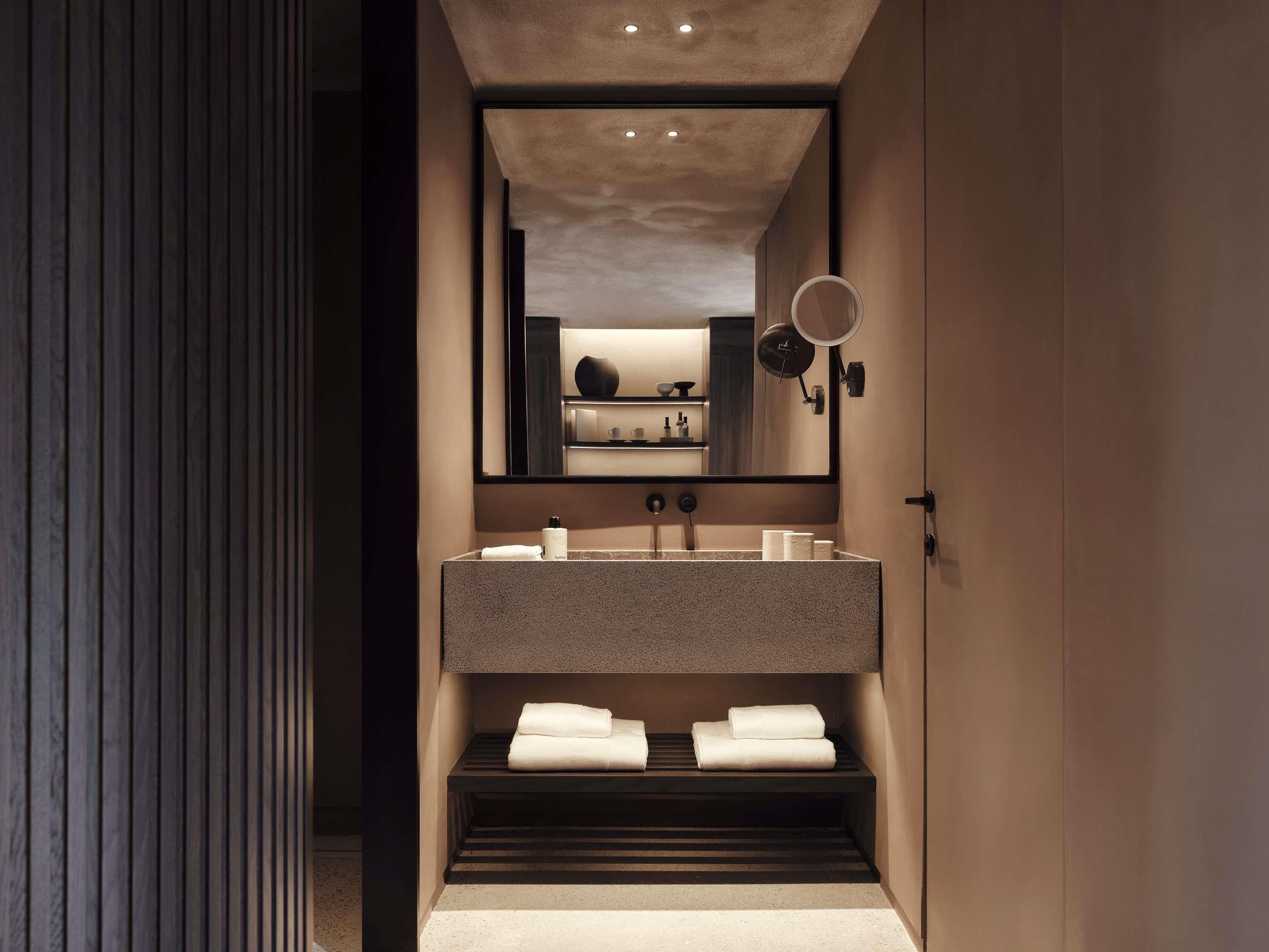 A modern bathroom with a large mirror, a countertop sink, and a towel rack.