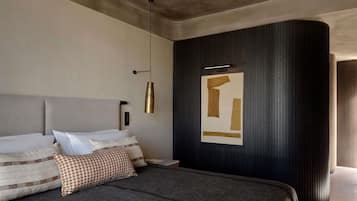 Un dormitorio moderno con una cama grande, un aplique de pared y una obra de arte abstracta única.