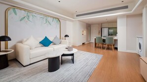 Un salon moderne comprenant un canapé, une table basse et un coin repas avec des chaises.