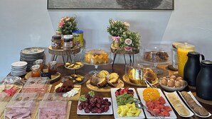 Ein reichhaltiges Frühstücksbuffet mit Speisen und einem Bild an der Wand.