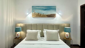 Ein Hotelzimmer mit einem großen Bett, zwei Nachttischen mit Lampen, einem Wandbild und einem Fenster mit Vorhängen.