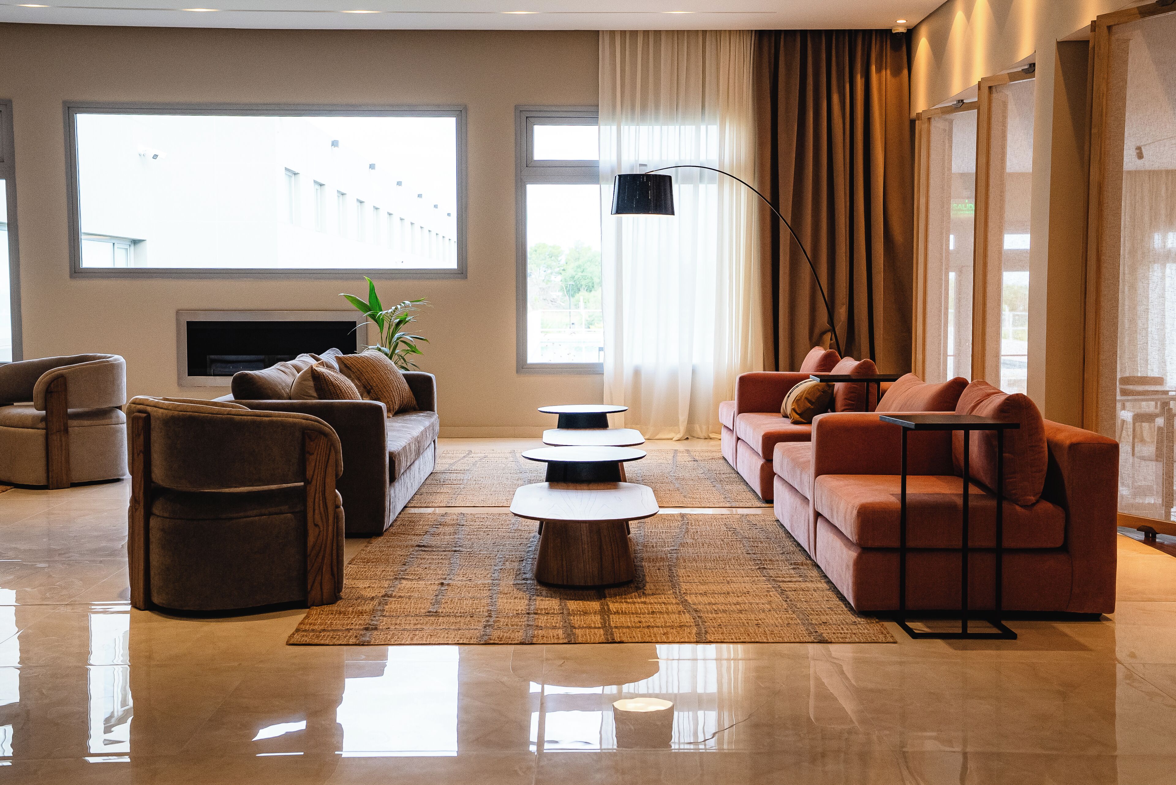 Una sala de estar moderna con un sofá, sillones, una mesa de centro y un televisor.