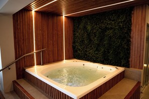 A hot tub with wooden paneling and a green wall. - Howard Johnson Hotel & Spa Bahía Blanca (Bahía Blanca)