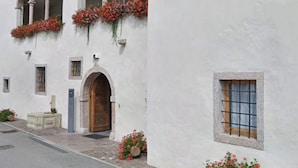 A building with white walls, wooden shutters, and flower boxes. - Hotel Soran (San Lorenzo Dorsino)