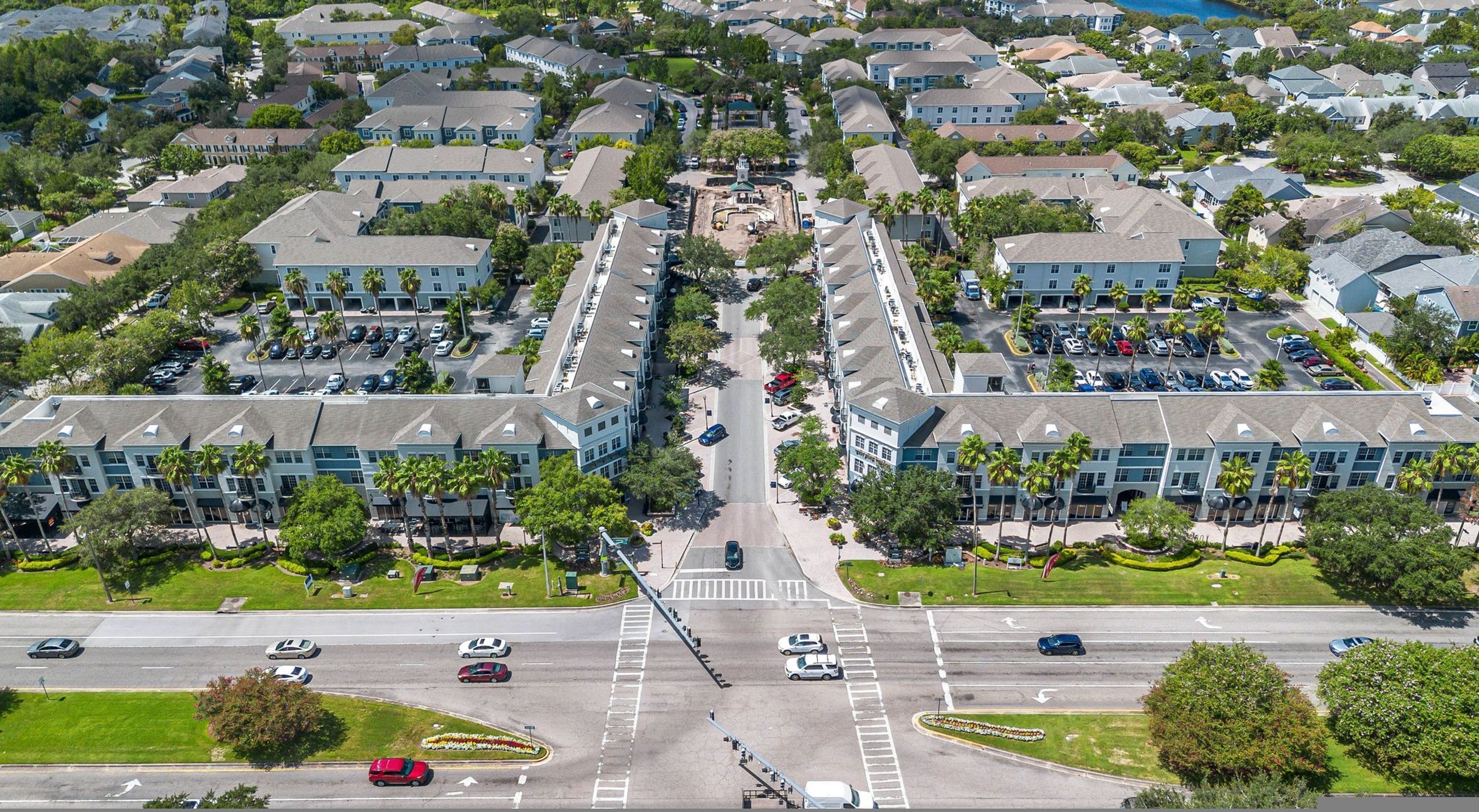 Een woonwijk met een centrale weg, huizen en een parkeerplaats.