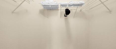 A laundry area with metal drying racks and folded towels.