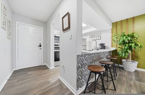 Una cocina con una barra de café, una puerta y una planta en maceta.
