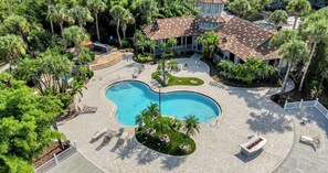 A large swimming pool surrounded by palm trees and a gazebo, with a patio area and lounge chairs. - Vibrant 2BR 2BA w King Bed Pool Gym 11 (Tampa)