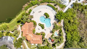 An aerial view of a resort with a swimming pool, a covered patio, and lush greenery. - Vibrant 2BR 2BA w King Bed Pool Gym 11 (Tampa)