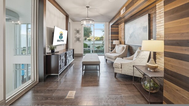 A spacious living area with a large window, a sofa, a coffee table, and a TV mounted on the wall. - Stylish 2BR w Pool Pet-friendly Unit 13 (Tampa)