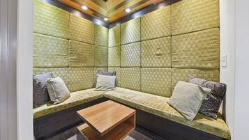 A room with a seating area, a wooden coffee table, and patterned walls.