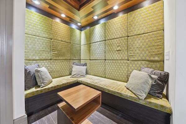 A room with a seating area, a wooden coffee table, and patterned walls. - Chic 2BR w Pool Pet-friendly Unit 14 (Tampa)