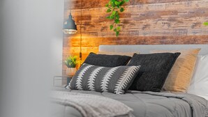 A bed with grey bedding, a black and white patterned pillow, and a grey throw blanket. - Stylish 2BR 2BA w Pool Gym Near Airport 3 (Tampa)
