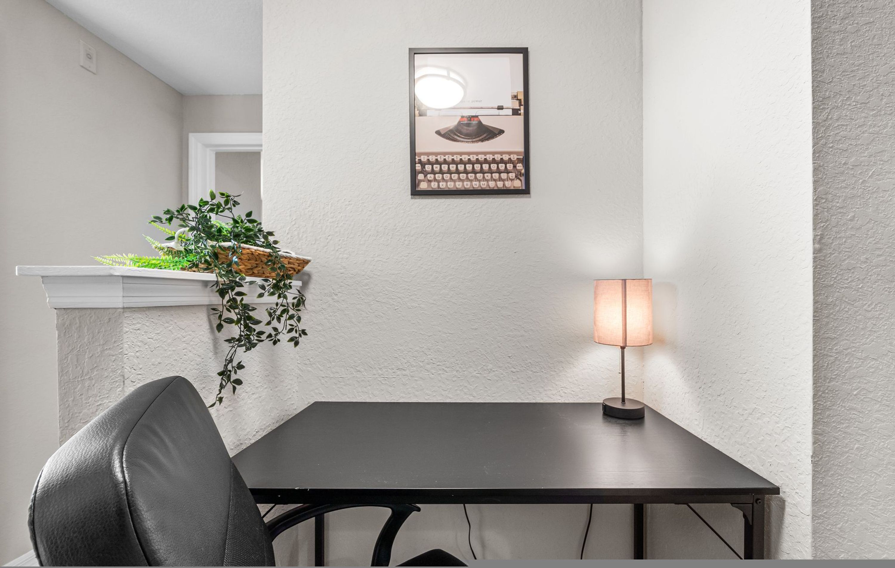 Ein kleiner Essbereich mit Tisch, Stuhl, Wandlampe und einem gerahmten Bild.