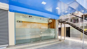 A modern building with a glass facade, a staircase, and a tiled floor. - Super Collection O Ahmedabad Airport (Ahmedabad)