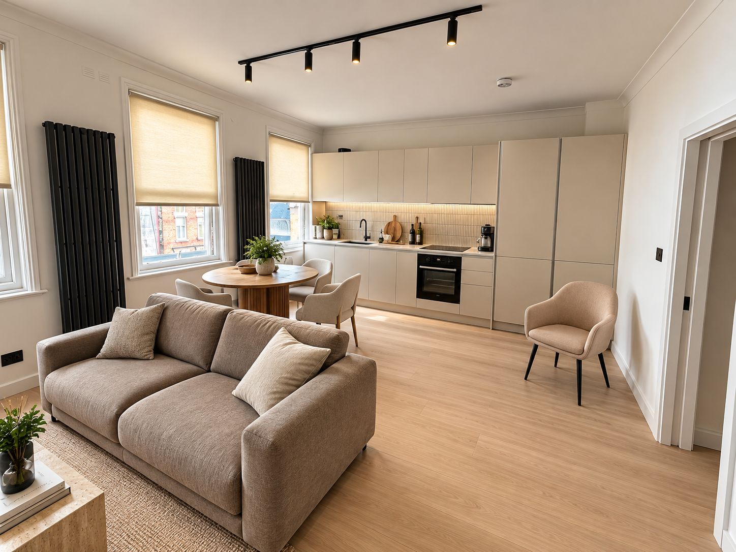 Un intérieur moderne comprenant un canapé, une table à manger, une cuisine et une chaise.