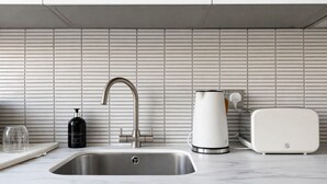 Eine moderne Küche mit Spüle aus Edelstahl, einem Wasserkocher und einem Toaster.