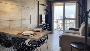 A modern living room with a dining area, large windows, and a city view. - SP New Home (São Paulo)