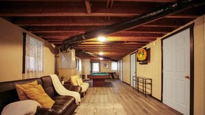 Ein Zimmer mit Poolbillard, einer Couch, einer Tür und einem Schild für Ferienwohnungen.