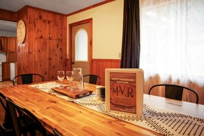 A wooden dining table with a menu stand, glasses, and a pitcher. - Misty Mountain Cottage - Pet Friendly (Shippen Township)