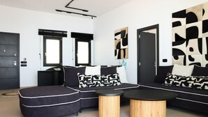 Ein modernes Wohnzimmer mit Ecksofa, rundem Couchtisch und abstrakter Wandkunst.