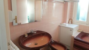 A bathroom with a large mirror, a sink, a toilet, and a window. - CHATOU CITY CENTER (Chatou)