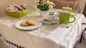 Ein Tisch ist gedeckt mit Keksen, einer Kaffeetasse, einer grünen Tasse und einer Schale mit Biscotti.
