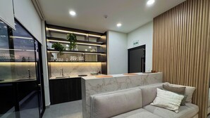 A modern kitchen with a marble countertop, a built-in sink, and a black refrigerator. - Luxurious brand-new apartment just a few blocks from Larcomar (Miraflores)