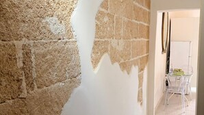 A room with a partially painted wall, a whiteboard, and a clear glass table with chairs. - Le Dimore - Suite Levante (Gallipoli)