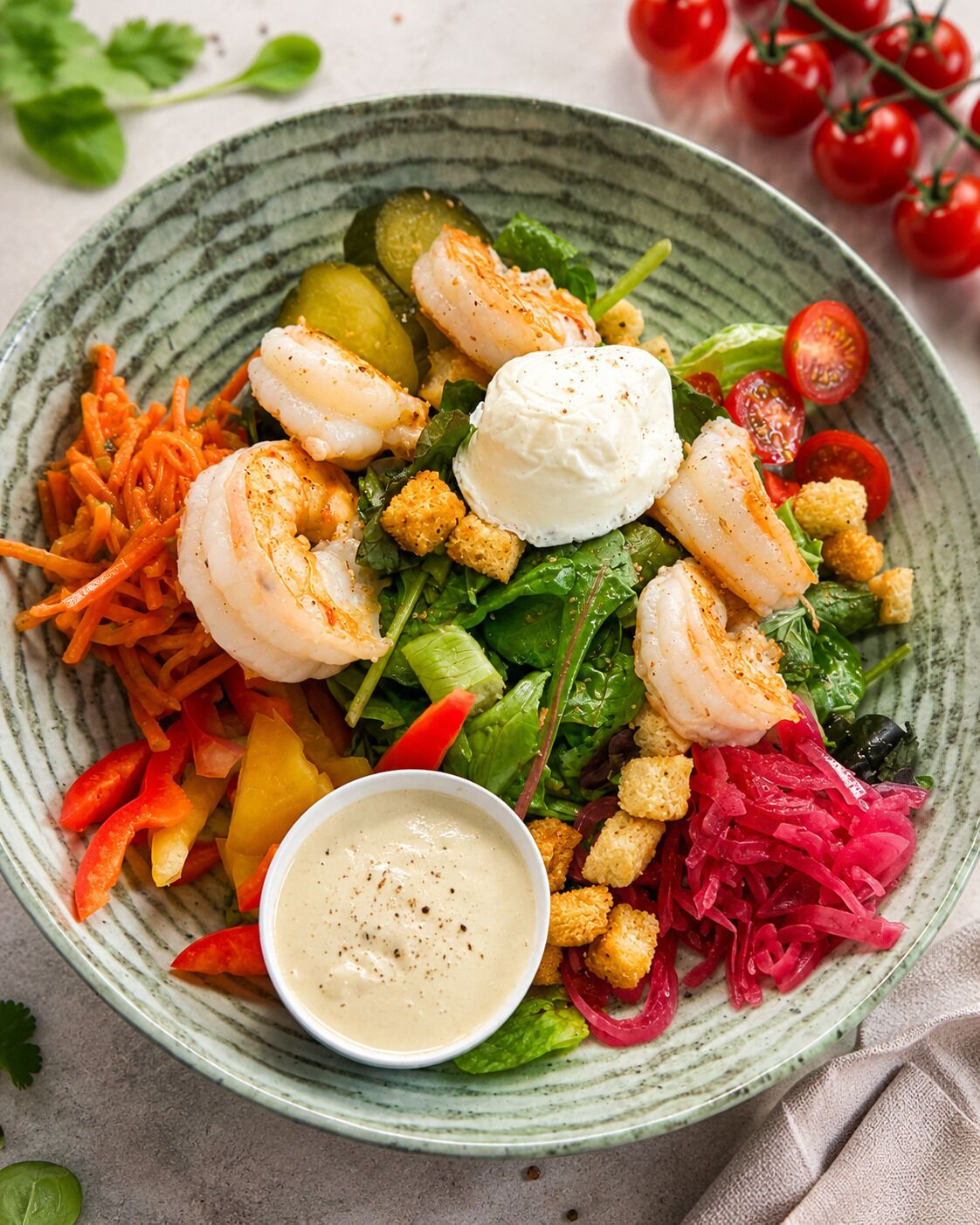 A plate of food with shrimp, vegetables, and a creamy sauce.