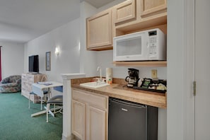 A compact kitchen with a microwave, coffee maker, and dishwasher. - Studio w/ Gym & Pool Access (Pigeon)