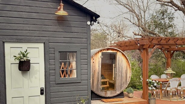 A rustic cabin with a door, a small window, and a wooden sauna structure. - Cozy 4-bedroom cottage + tiny house in walkable to downtown Franklin with sauna (Franklin)