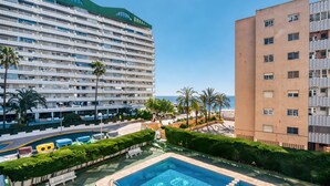 A hotel with a pool, palm trees, and a view of the sea. - Apartment 'Rosa De Los Vientos' with Sea View, Wi-Fi, and Air Conditioning (Calpe)