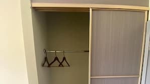 Een inloopkast met een houten deur en een kledingroede.